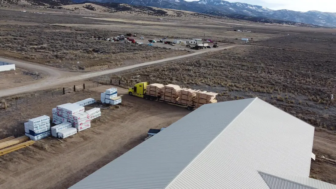 Semi truck loaded with building kits departing the facility